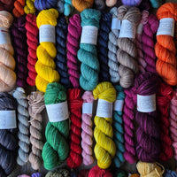 Assorted colorful yarn skeins on a wooden surface